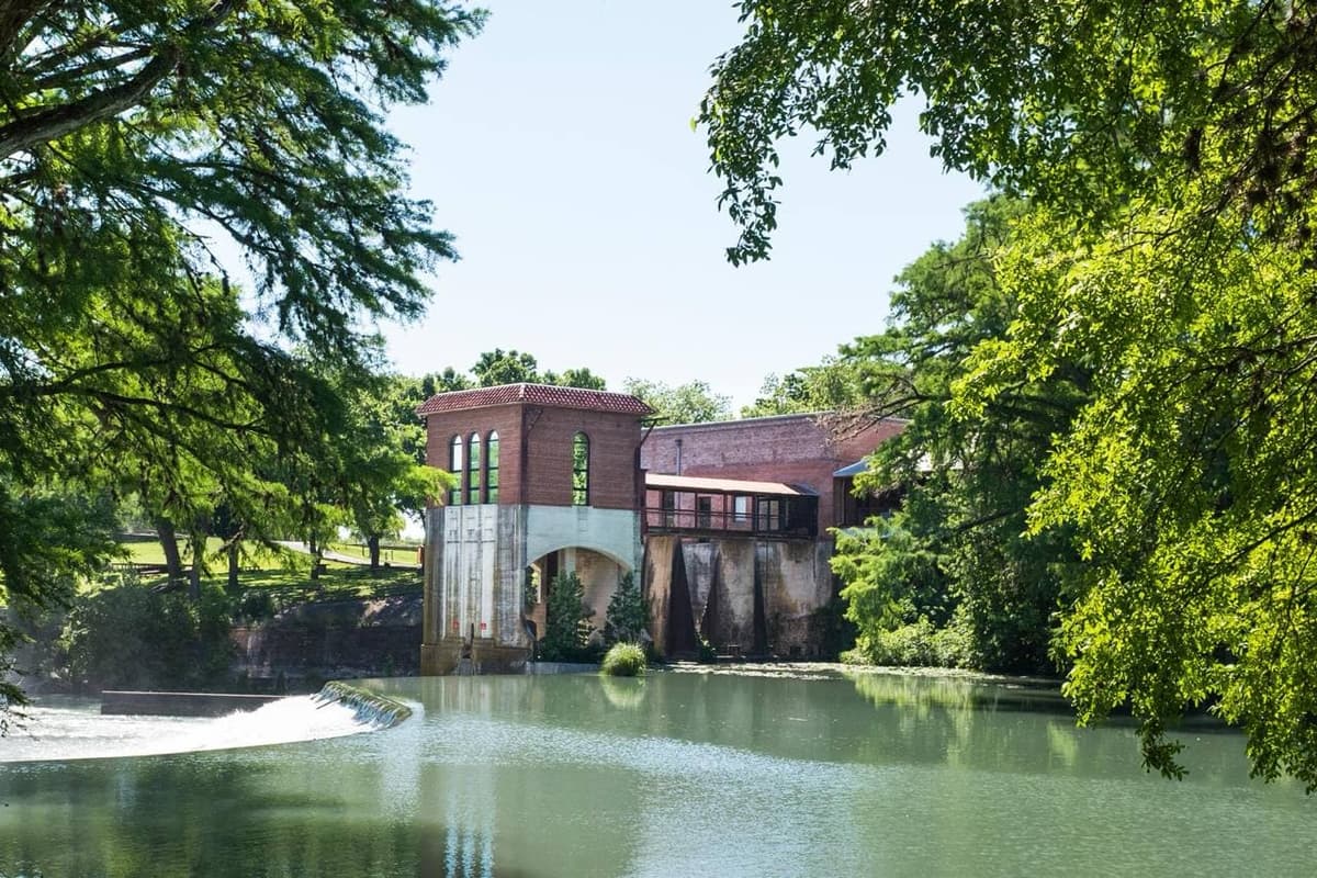 Historic Seguin Texas riverfront with brick powerhouse and dam on the Guadalupe River