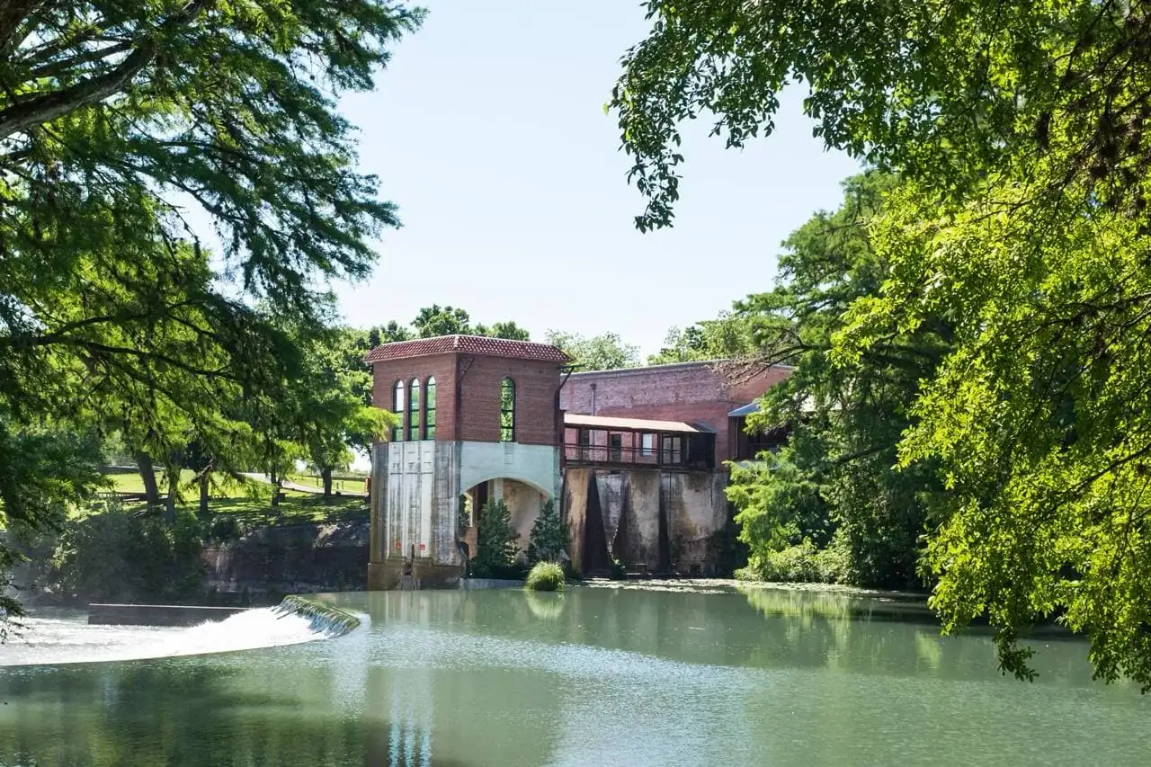 Historic Seguin Texas riverfront with brick powerhouse and dam on the Guadalupe River