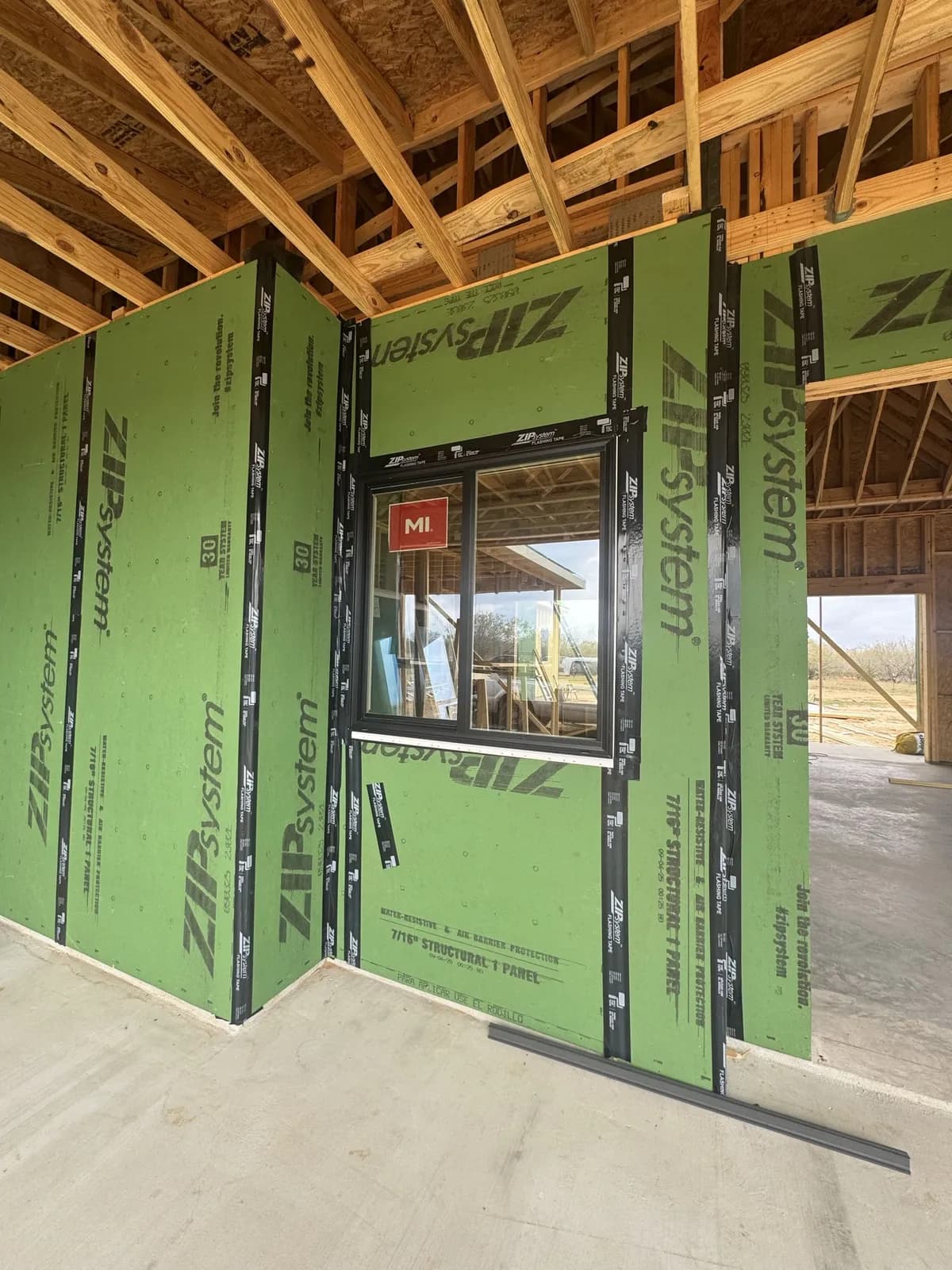 Green ZIP System sheathing on the framed walls of a TKG build