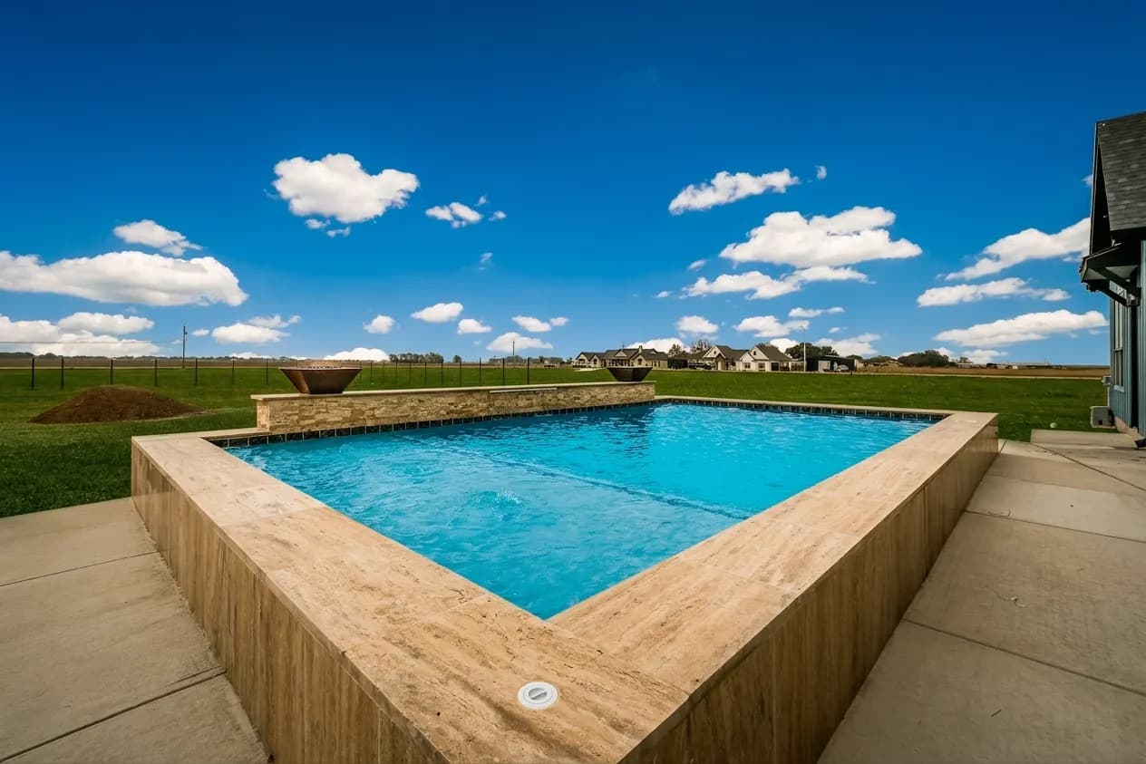 A raised gunite pool by Turner Custom Pools against open hill country