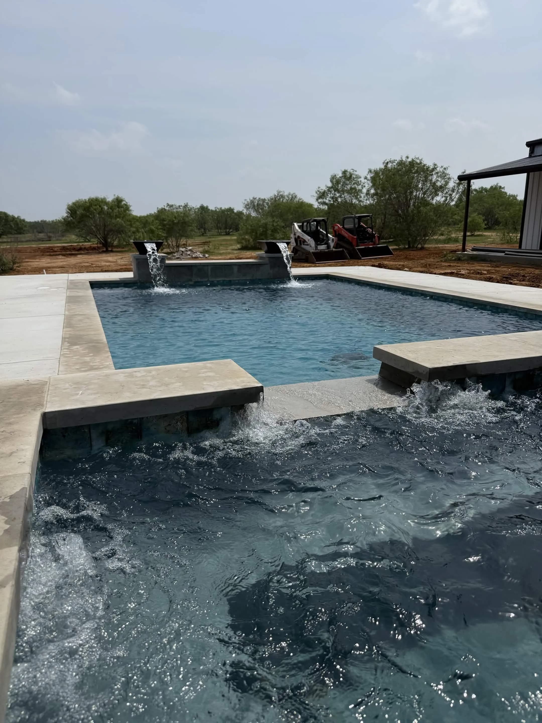 Water features running over the spa wall of a Turner Custom Pools build